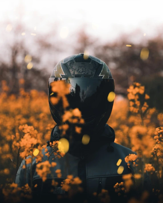 a person wearing a motorcycle helmet and goggles standing in front of a field