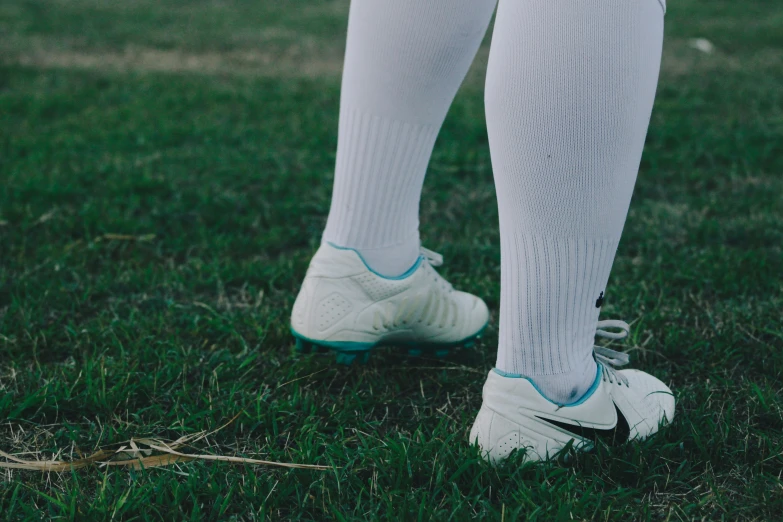 the soccer player is on the grass with his feet up