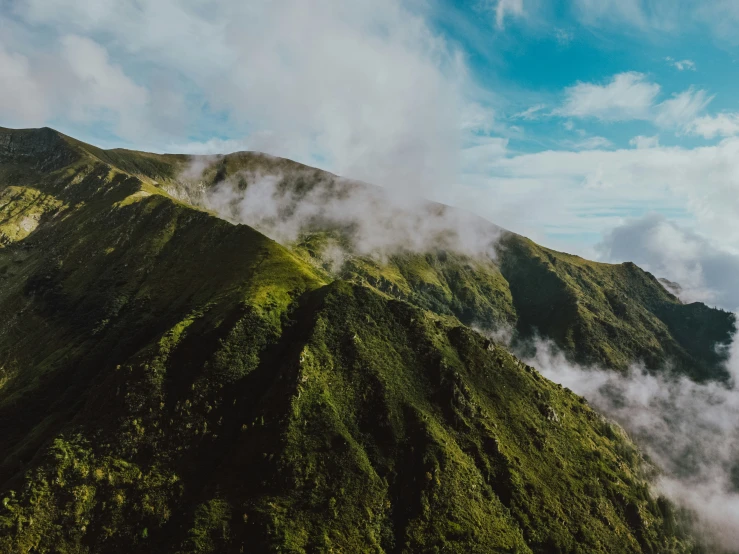 a very high mountain covered with clouds in the sky