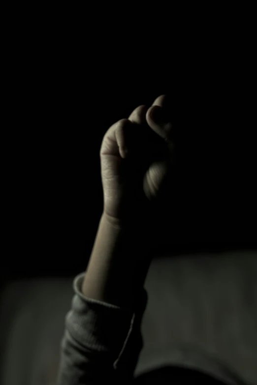 the arm of a person sitting in a darkened room