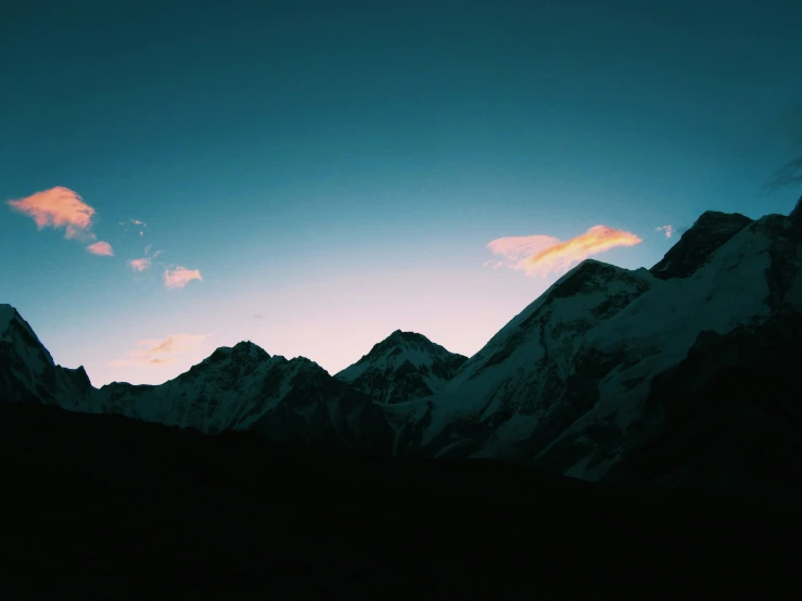 a few clouds and mountains as the sun sets