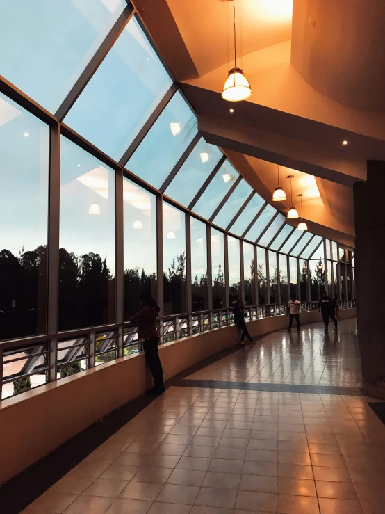 several people standing on the sidewalk in an empty room