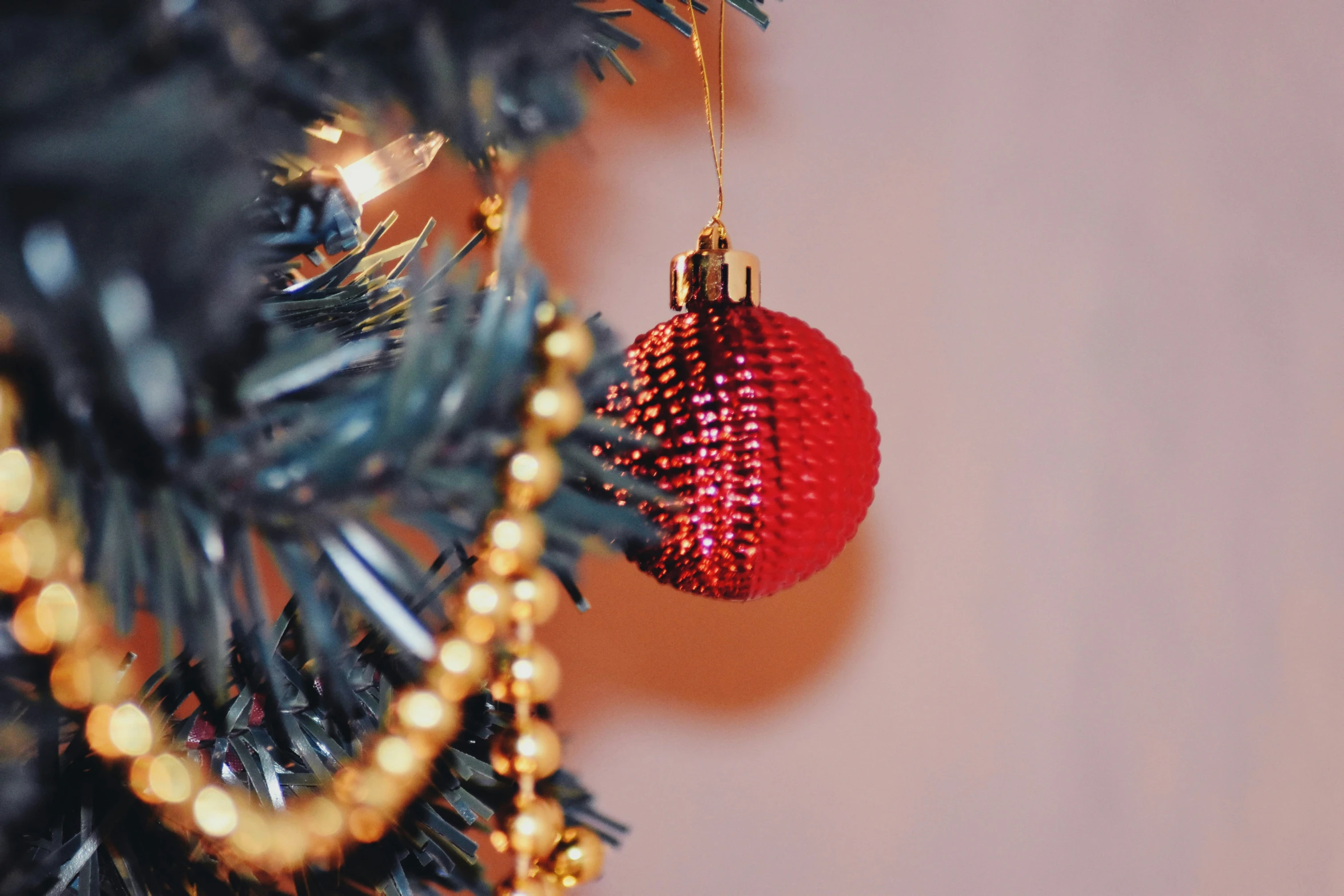 a red ornament hanging on a christmas tree