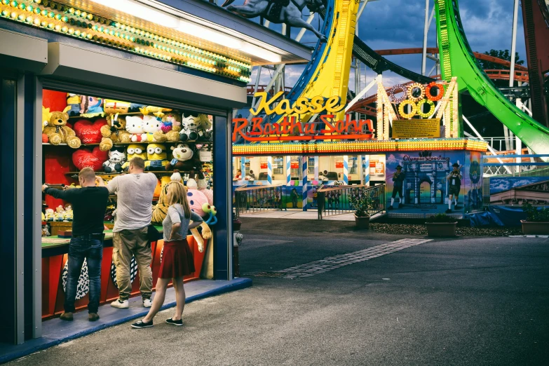 people standing outside of the carnival booth in the night