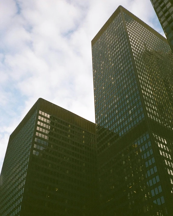 a couple of skyscrs against a partly cloudy sky