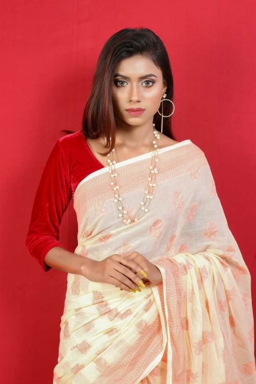a woman in a white and yellow sari with a beaded necklace
