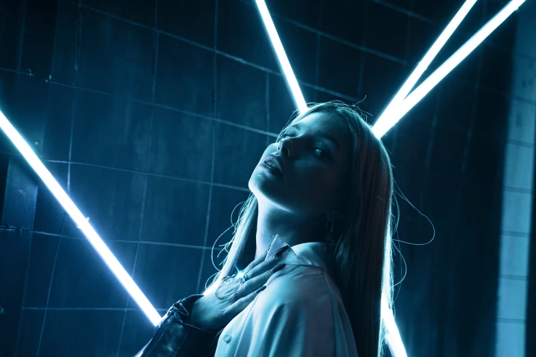 a beautiful woman standing against a wall with three lights