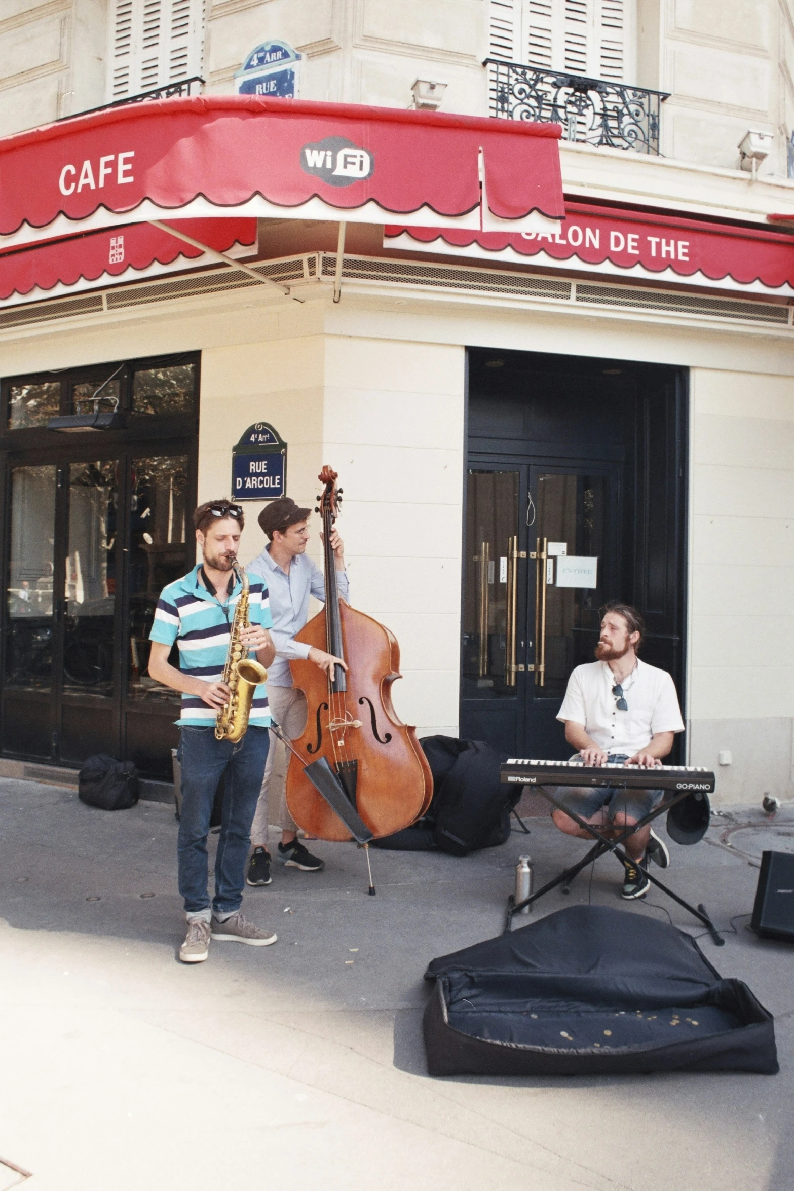 band performing on sidewalk in front of cafe