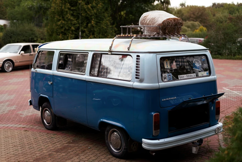 an old bus parked in front of a van with luggage on top of it