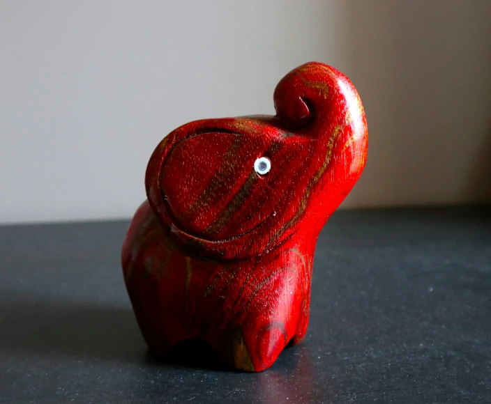 red wooden sculpture of an elephant standing on a table