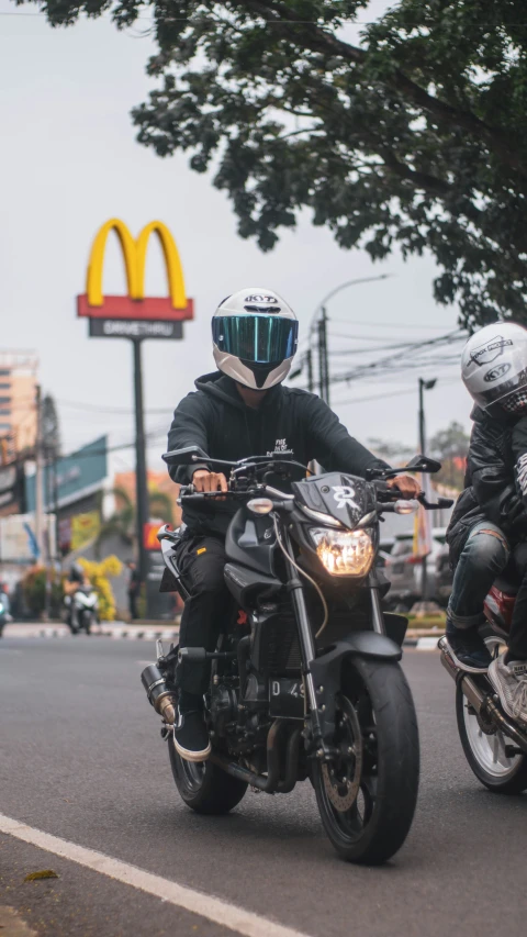 two people are riding on motorcycles down the road