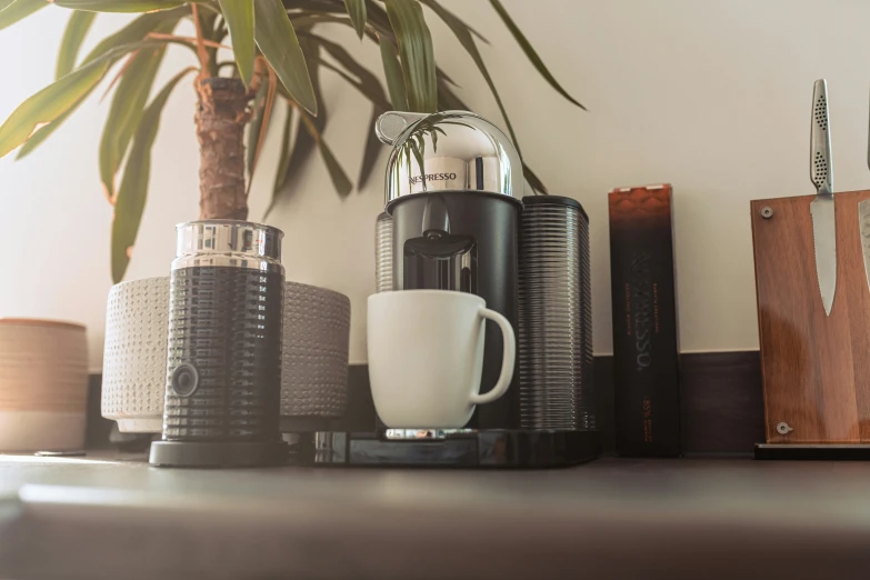 a counter has coffee pots, and knives on it