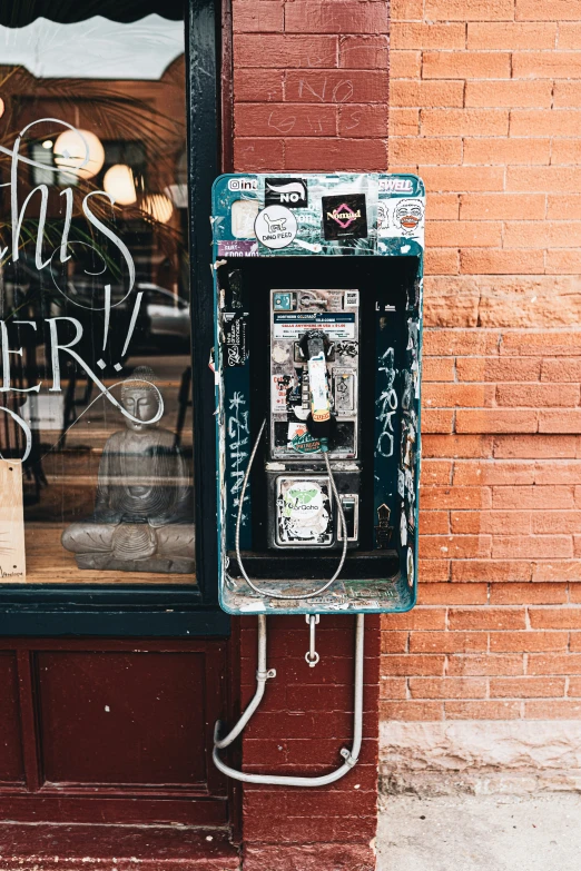 an old fashioned pay phone on the side of the street