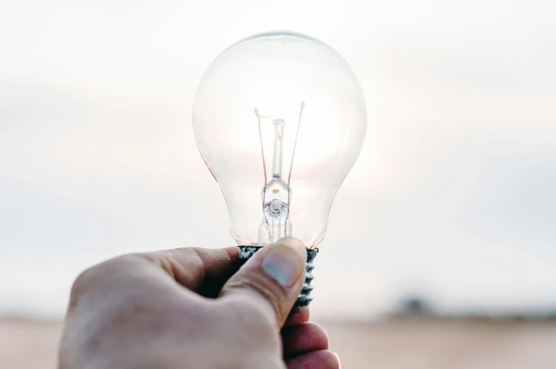 someone holding an electric light bulb for the light