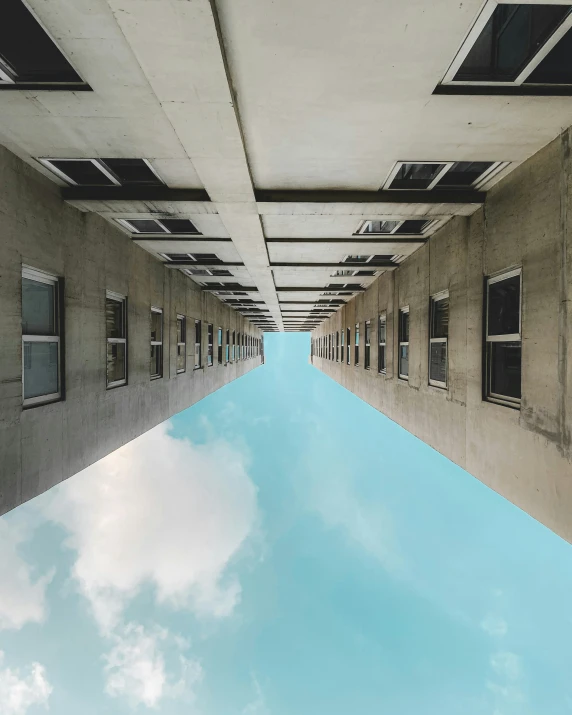 a narrow building with lots of windows, reflecting the sky