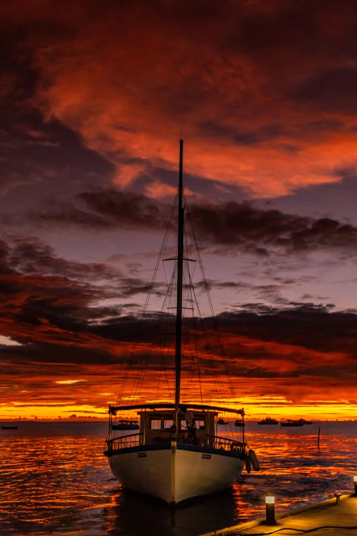 a boat sitting in the water under a cloudy sky