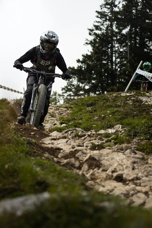 a man rides a dirt bike on a rocky path