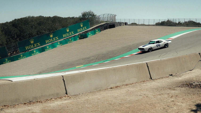 a race car is driving along the course at a racetrack