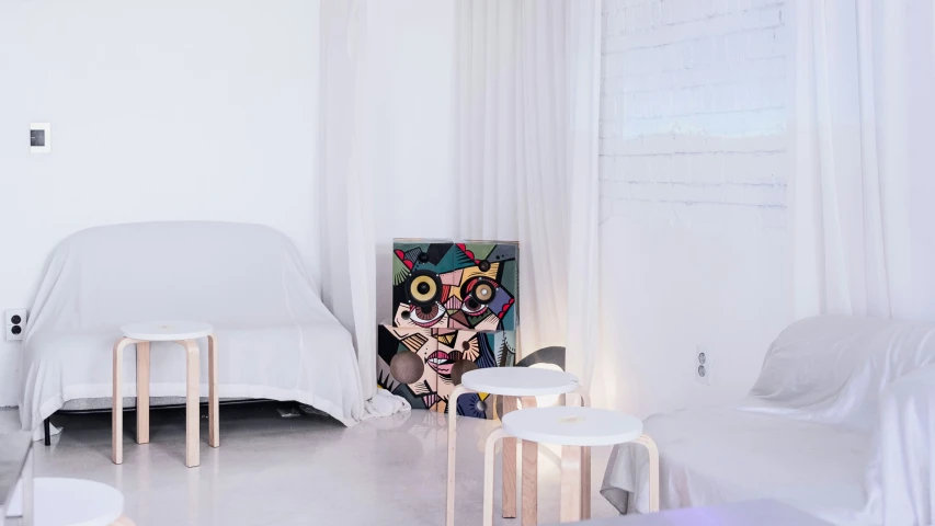 there are two tables on the floor in front of a white couch