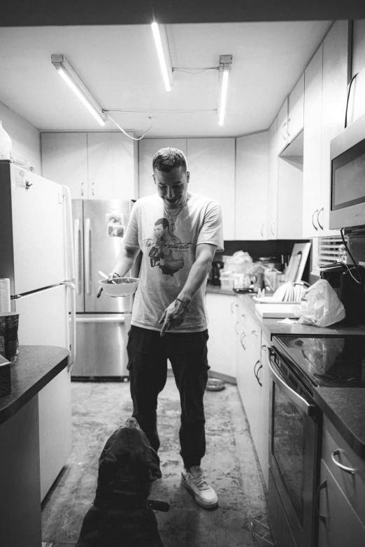 a man and his dog in a small kitchen