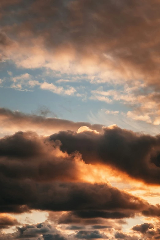 the airplane is flying into the clouds at sunset