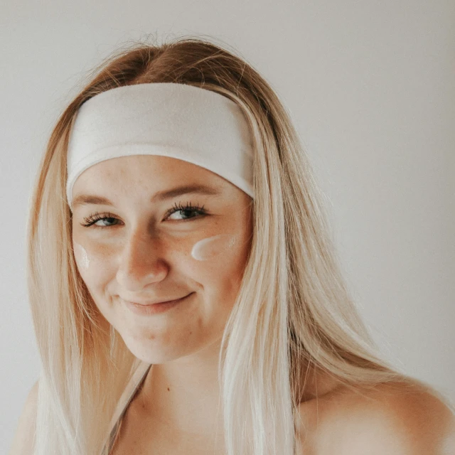 woman in a towel around her face posing for the camera