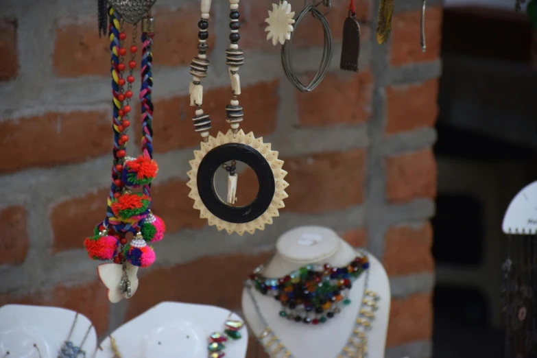 colorful beads hanging from a rope near a pair of jewelry