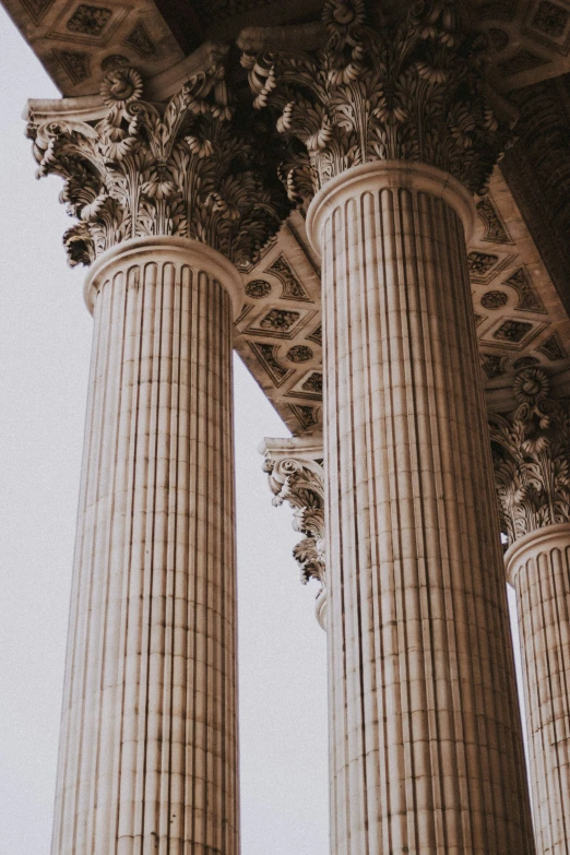 four tall pillar in a building with decorative designs on top