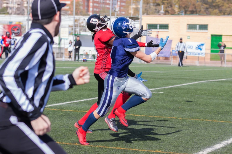 some football players on a field and one is holding a ball