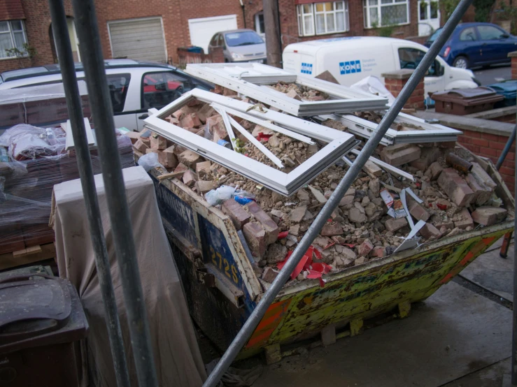 a truck filled with scrap wood next to a car