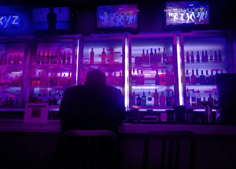 the silhouette of a bar with shelves full of liquor