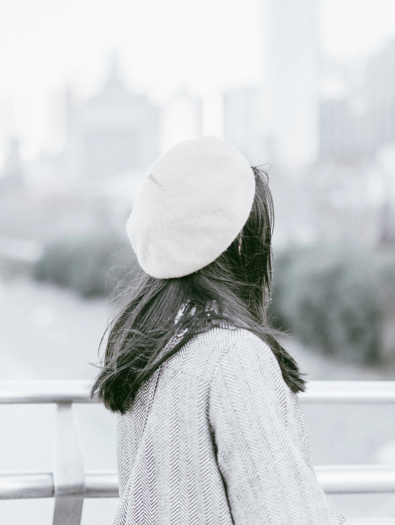 a woman sitting on top of a bridge next to the water