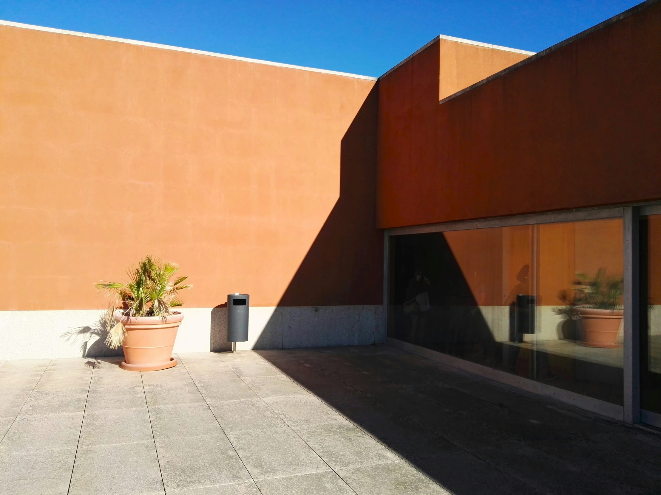 an orange wall with a brown planter sitting next to it