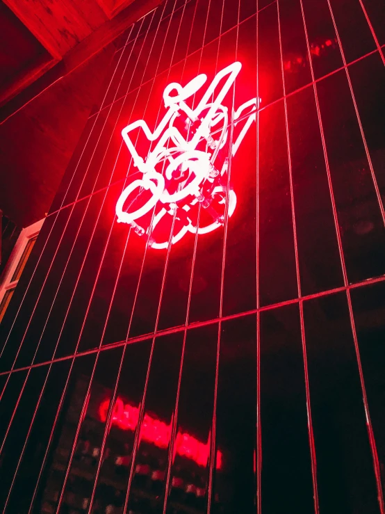 a neon sign on a building says hello kitty