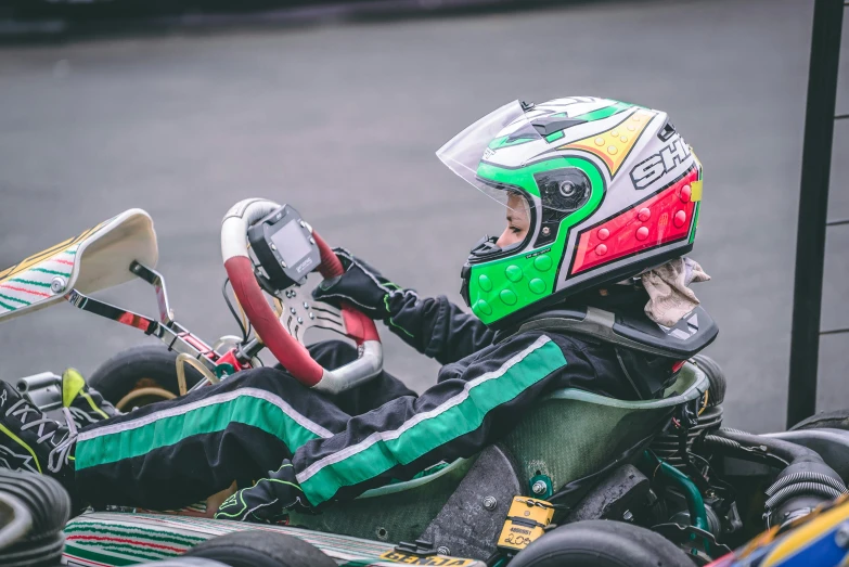 a person sitting in a racing car with two hands on the steering wheel