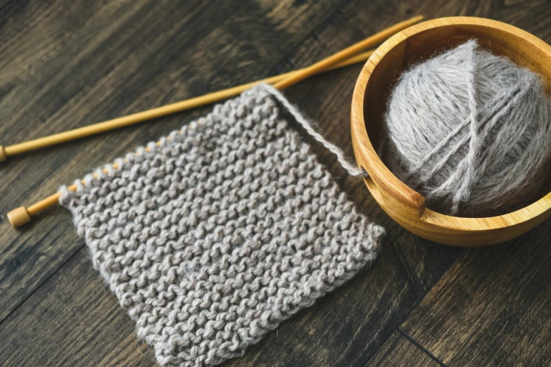 a crochet dishcloth and a yarn ball sitting on the floor