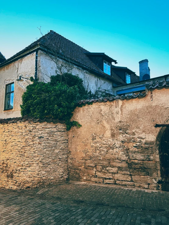 a stone building and brick walkway on a sunny day