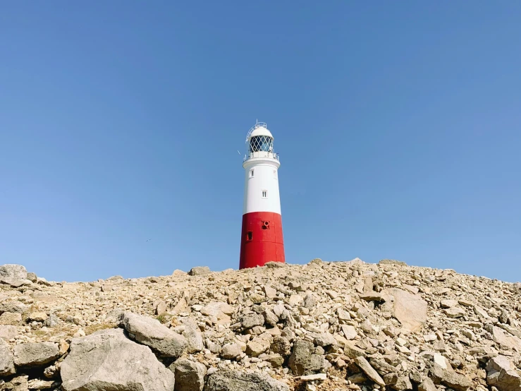 a red and white light house on the side of a cliff