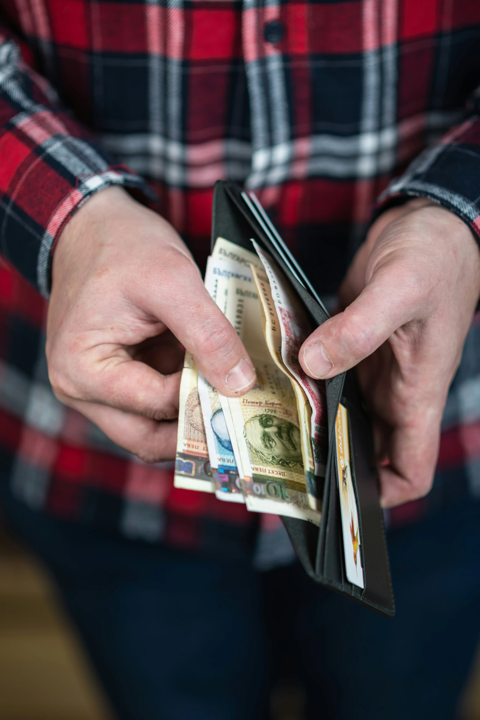 a person holding money in their wallet