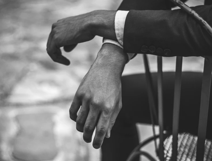 a hand holds onto a black chair