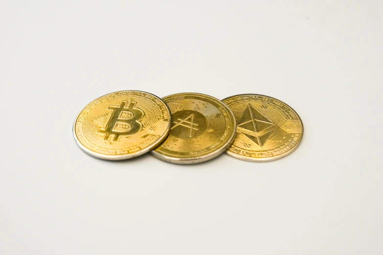 four gold colored bit coin sitting next to each other