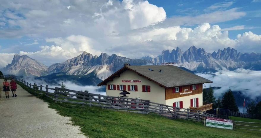 the wooden cabin is built on a hill near the mountains