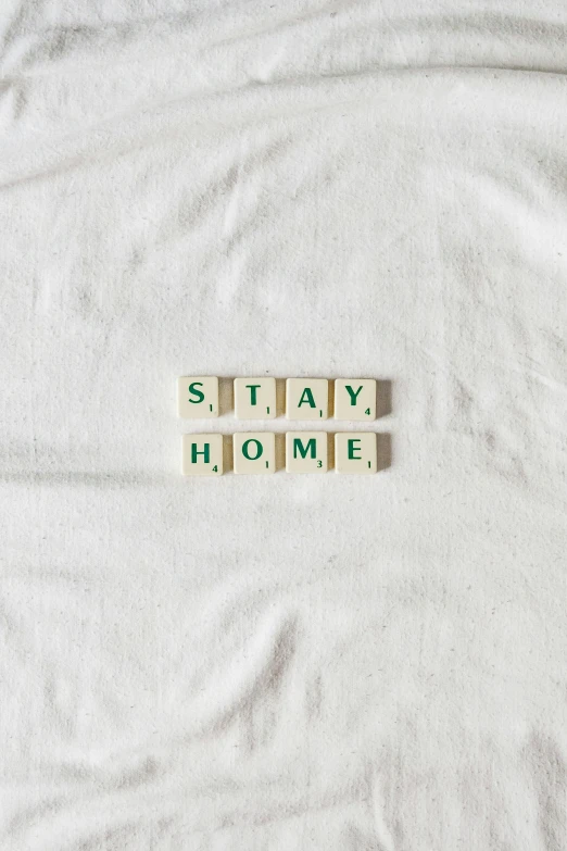 a stack of scrabble tiles sit on top of a blanket