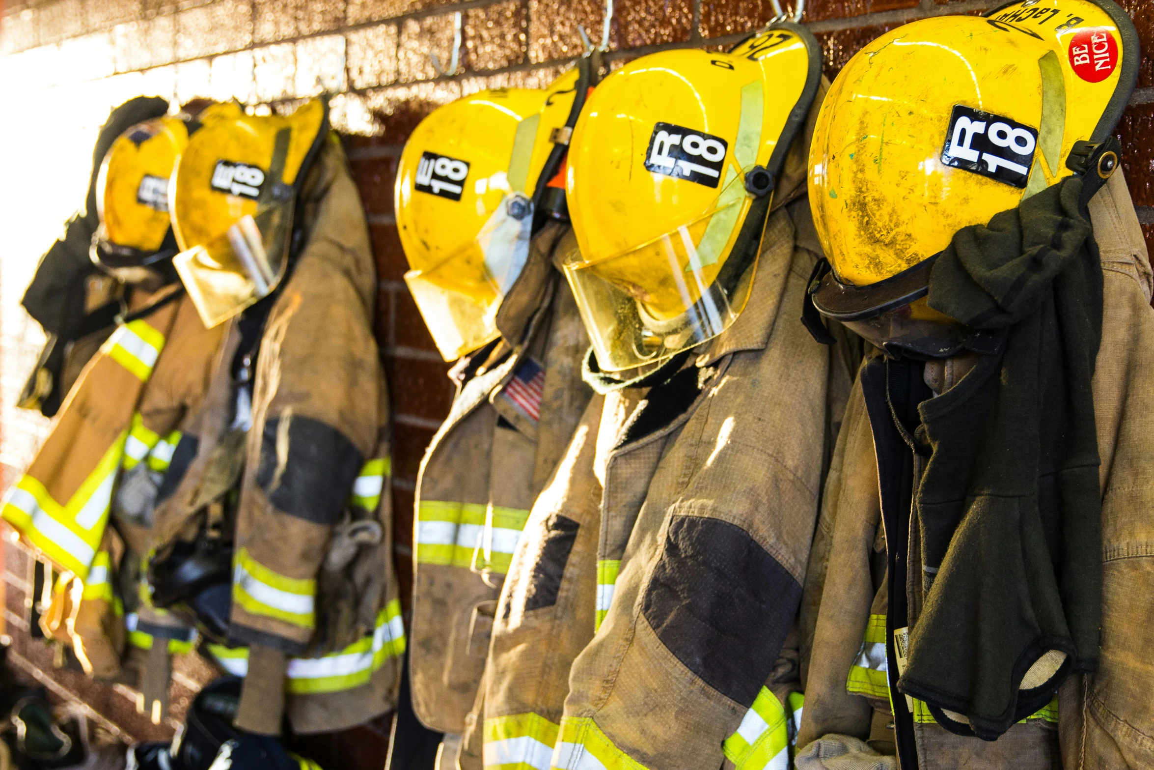 fire fighters lined up in their gear hanging on a wall