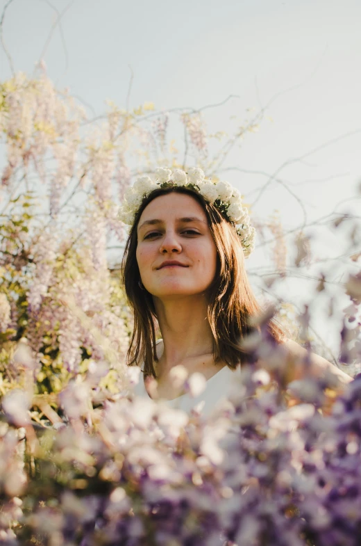 a woman is posing in a field filled with flowers