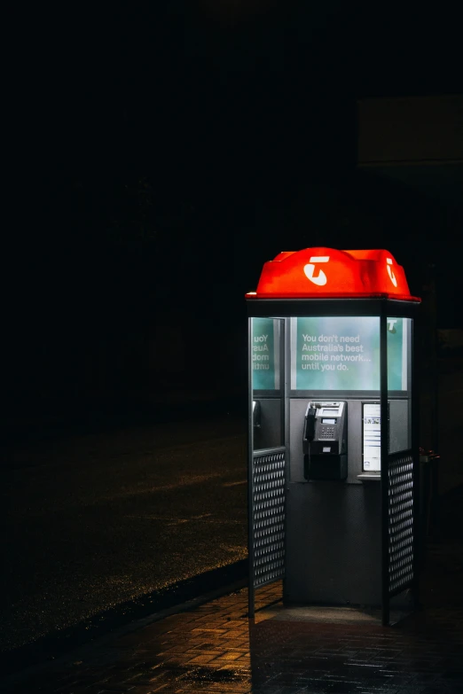 an illuminated parking machine on a dark street