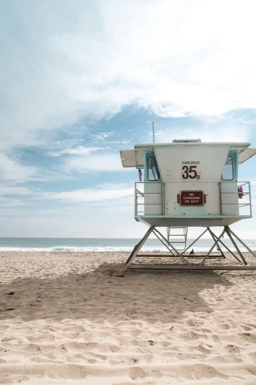 a lifeguards chair sits on a beach next to the ocean