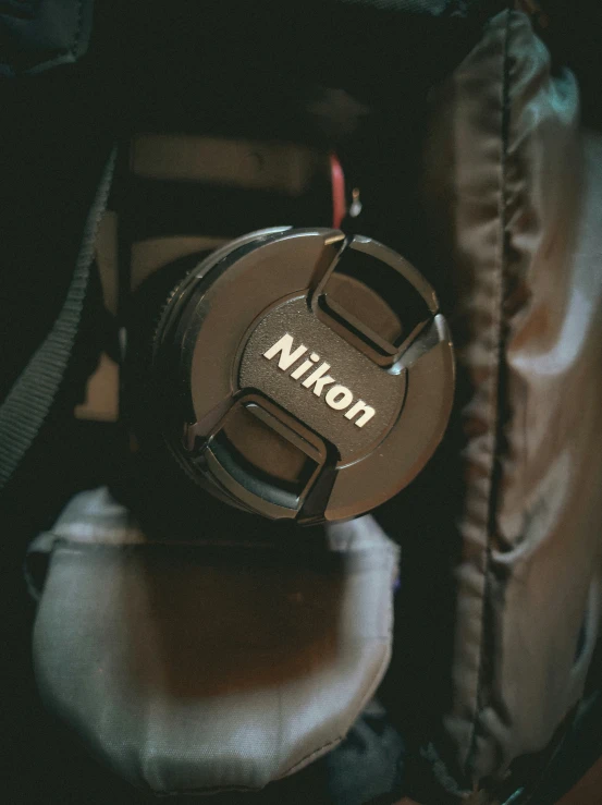 a nikon cap on a chair, with a keychain nearby