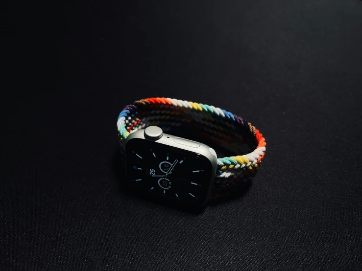 an apple watch with a multicolored wrap