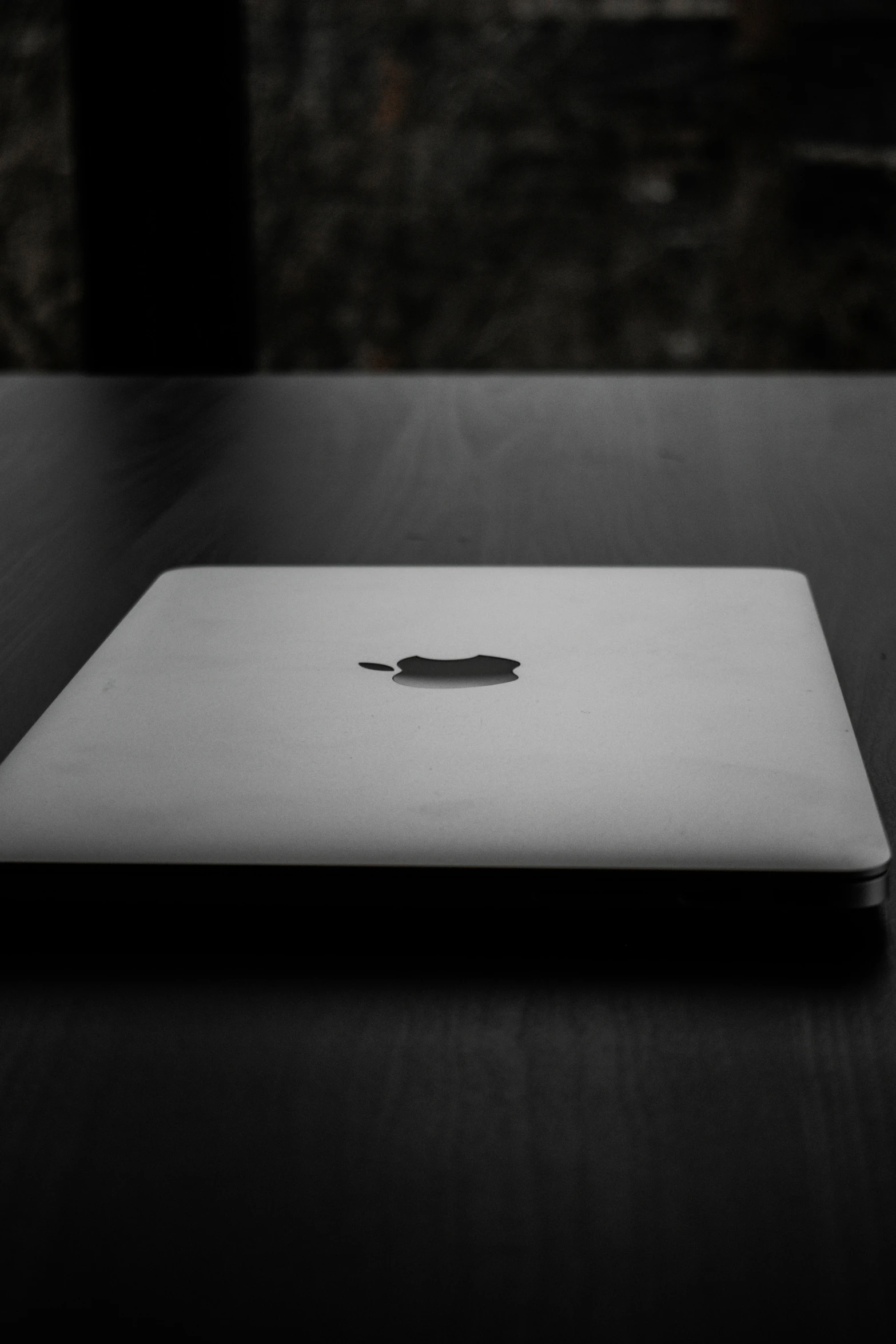 an apple laptop computer sitting on a black table
